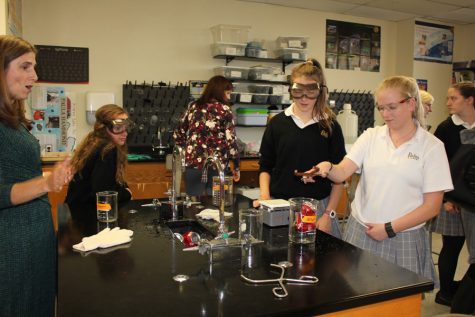 Katherine Halley '19 and Anne Fraser-Jones '19, perform a Chemistry experiment in front of guest