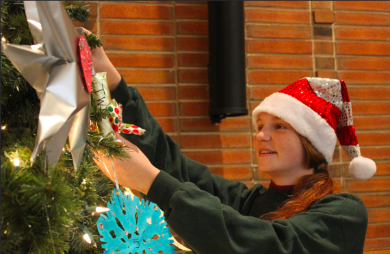 Representatives from each homeroom hang ornaments for their class