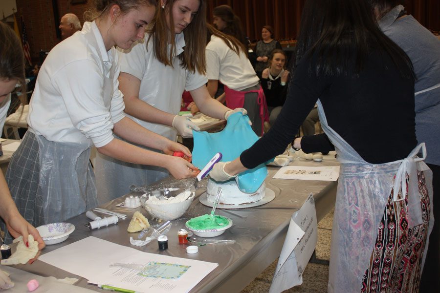 Sophomores Caitlin Stoddard and Caitie Baxter put blue fondant on icing. 