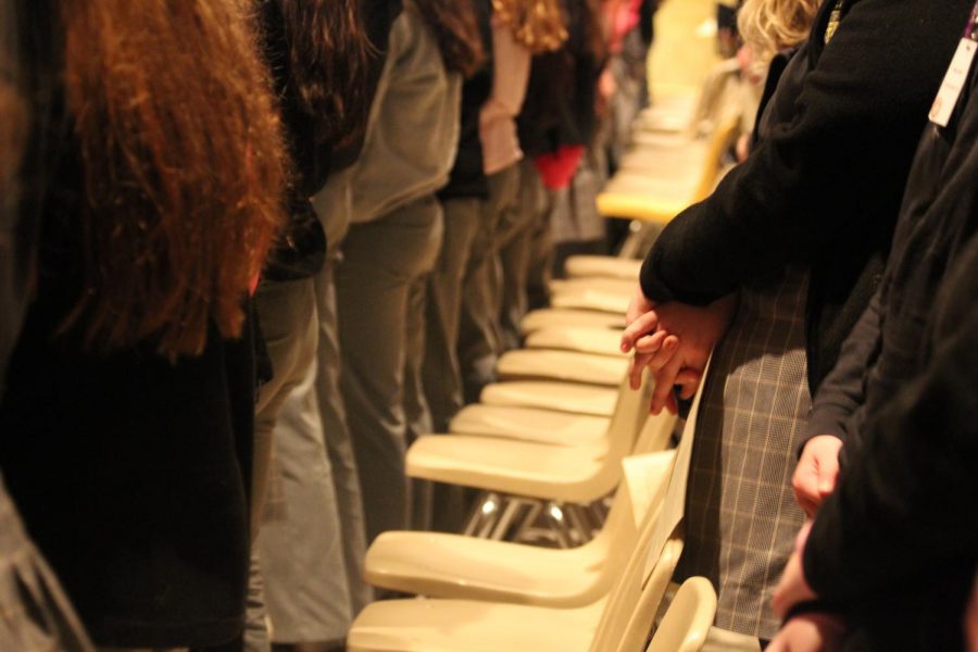 Students stand in prayer.