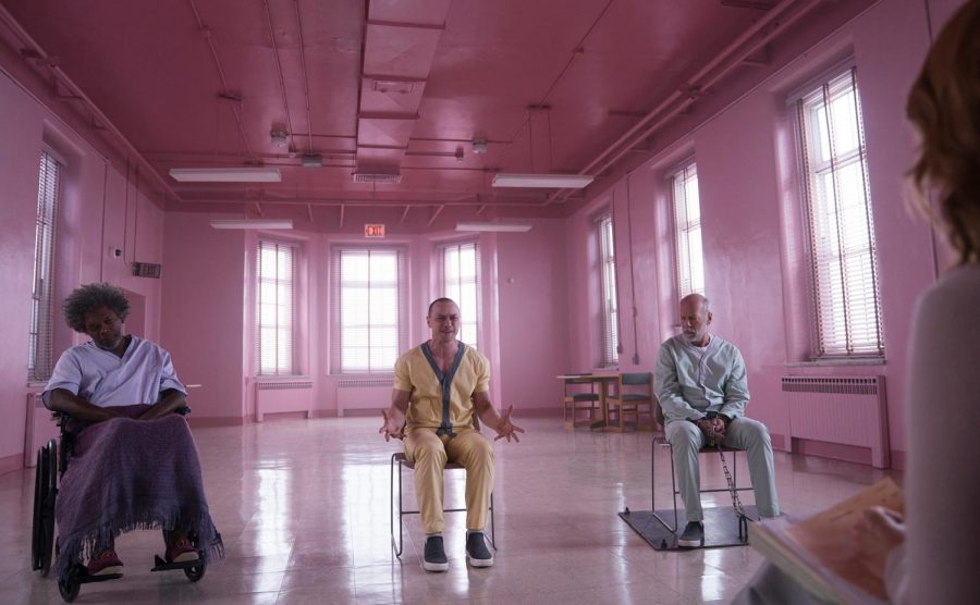 Elijah Prince (Samuel L. Jackson), Kevin Wendell Crumb (James McAvoy), and David Dunn (Bruce Willis) sit in a room while they are interrogated.