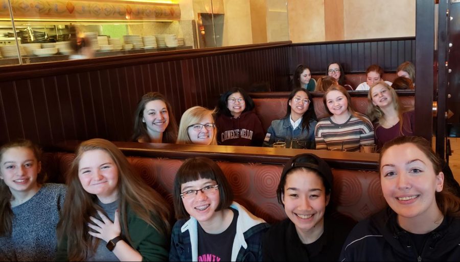 Team members smile during their celebratory dinner at the Cheesecake Factory.