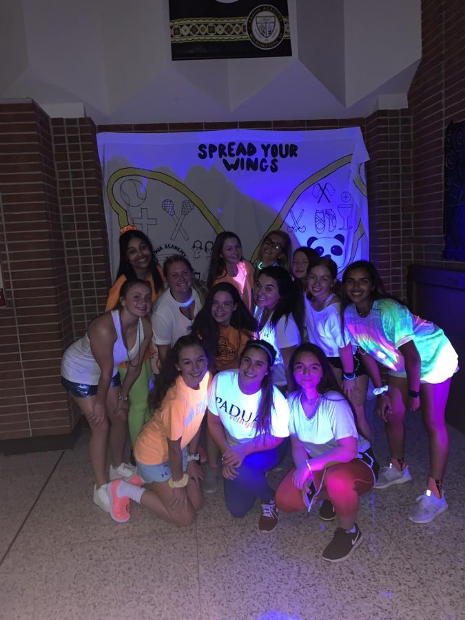 Students from the class of 2022 pose for a picture in the blacklight section