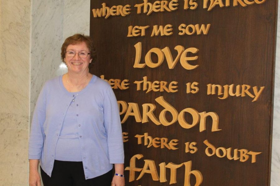 Dr. McClory poses in front of the prayer wall in the lobby. McClory said that her favorite part of her job is working with the staff. “Its really a pleasure to work with other people in our building- other adults that care about passionately about our school and our students,” she said.