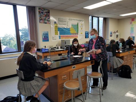 Mrs. Fundakowski hands out a test to her Honors Chemistry students. After an unexpected resignation, she and Dr. McClory stepped up to teach two chemistry sections each.