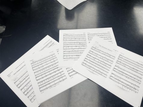 Sheet music is prepared for some songs from All Together Now! The set list includes Pure Imagination from Charlie and the Chocolate Factory and The Human Heart from Once On This Island.