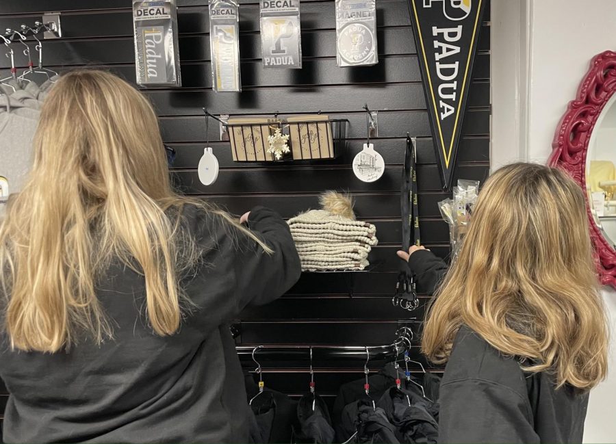Business leaders Annie McTaggart and Courtney LeNoir work together to organize the school store products. McTaggart said she enjoys the behind-the-scenes aspect of managing the school store.