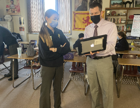 Mr. Cross shows student Hannah McGuigan what he is teaching in his Rise of Detective Fiction class during homeroom.