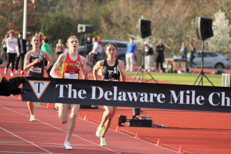 Senior Katie Dorsey competes in the fastest high school girls race of the night. Fans lined the outside of the track, cheering on the runners.